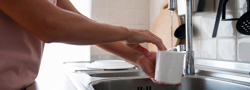 Women washing her mug with hard tap water